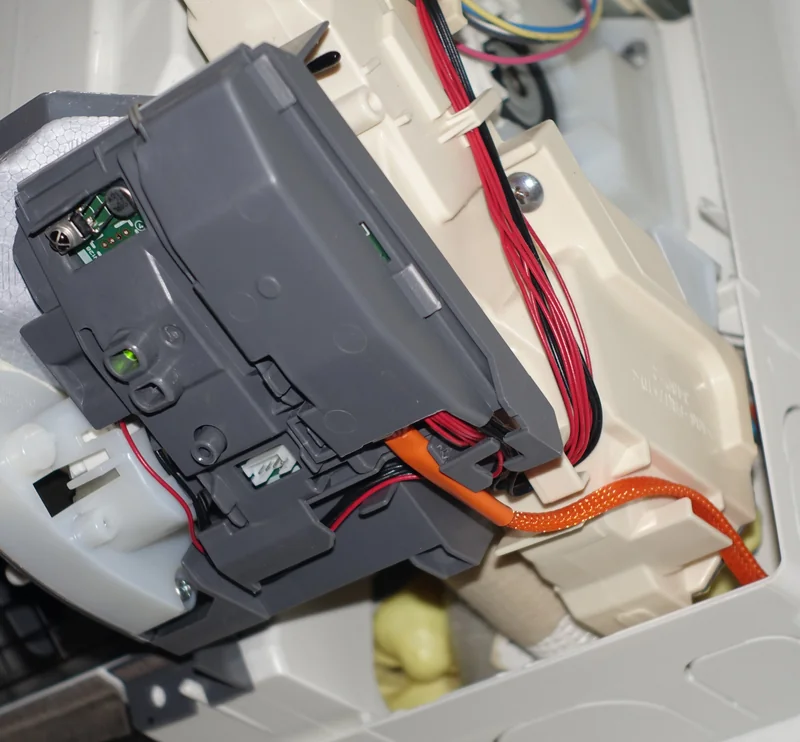 Orange CN105 cable routed beside the indoor unit's control-board enclosure