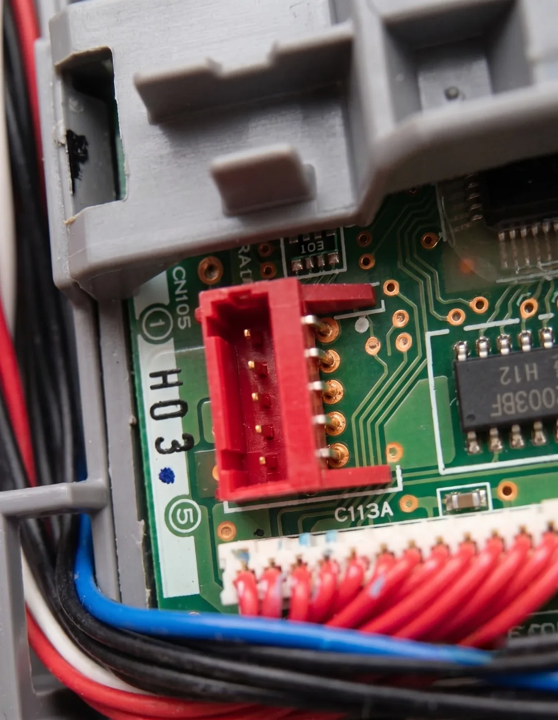 The empty red CN105 serial port on a Mitsubishi indoor unit's control board, with the CN105 label and pins 1 and 5 marked in the silkscreen