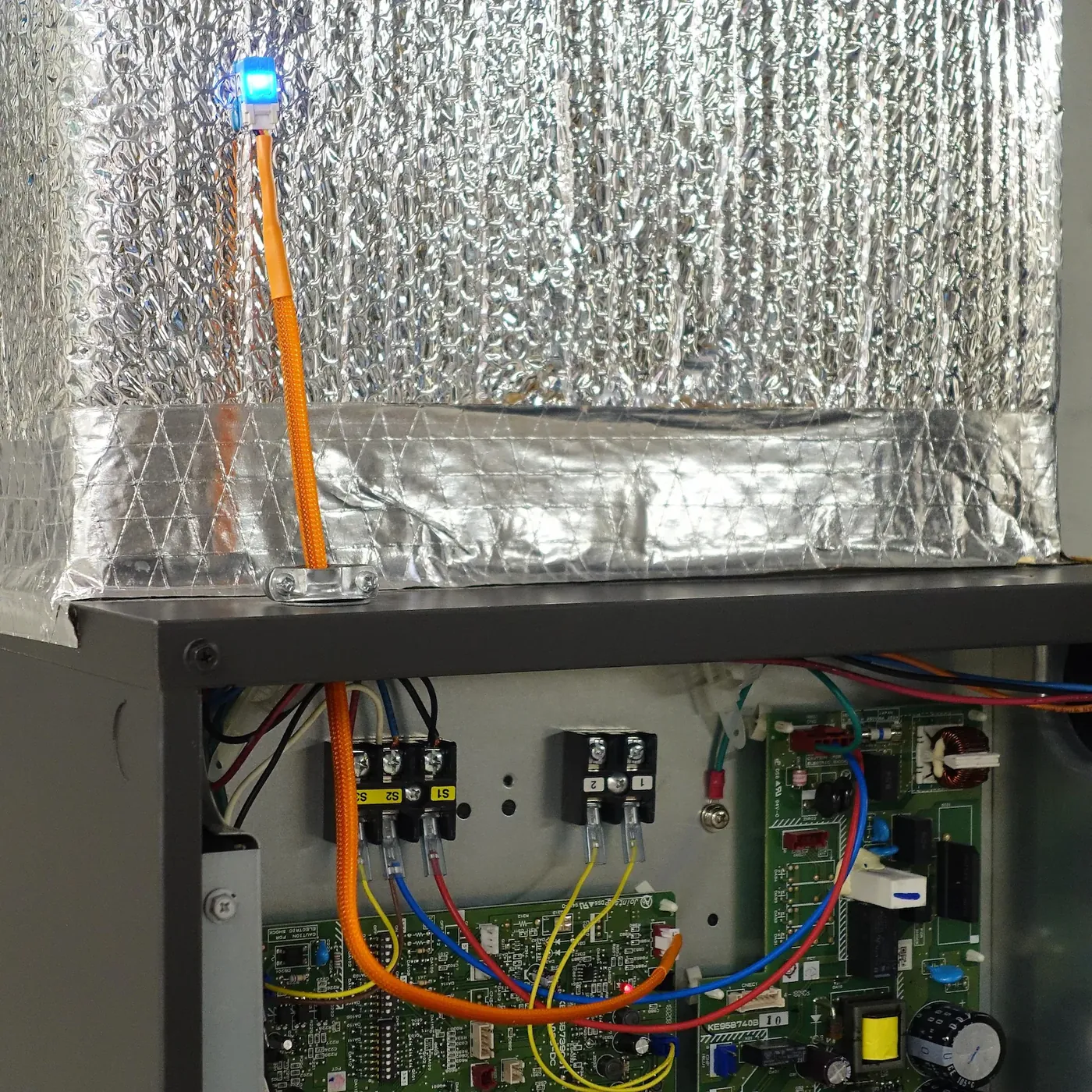 The Serin Controller mounted on the insulated plenum above a Mitsubishi MVZ air handler, connected by a 50 cm cable
